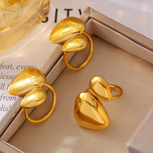 Three gold dual pebble rings displayed in beige jewelry tray