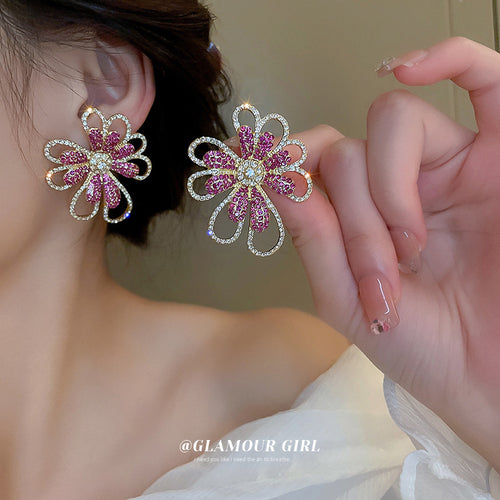 Styled close-up of pink crystal flower earrings