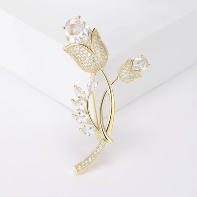 Front view of gold tulip stem brooch with clear stones against a white background.