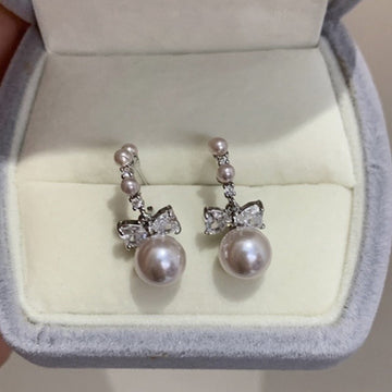 Pair of Metal Tone Pink Pearl Bow Stud Earrings with Clear Crystals