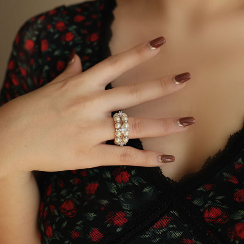 Silver pearl flower stretch ring worn on index finger