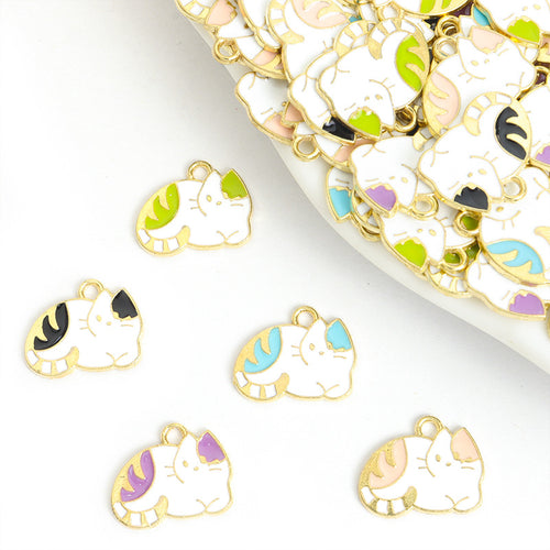 Assorted curled cat charms arranged beside a mixed pile