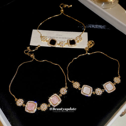 Black pink and white gold slider bracelets displayed on black surface