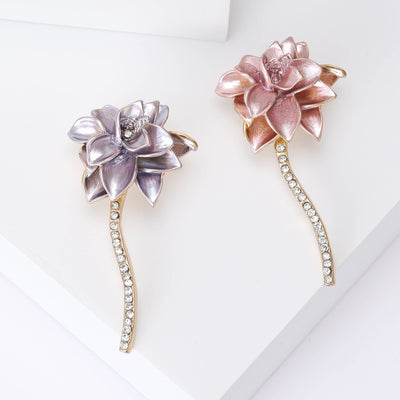 A layered pink flower on a long curved crystal-set stem shown on a white background