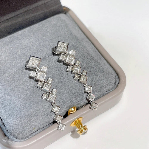 Pair of silver square cascade drop earrings in open gray jewelry box