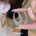 Textured Open Oval Huggie Earrings with Polished Metal Tone Details view 2