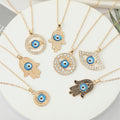 Gold Tone Blue Evil Eye and Hamsa Hand Pendant Necklaces view 1