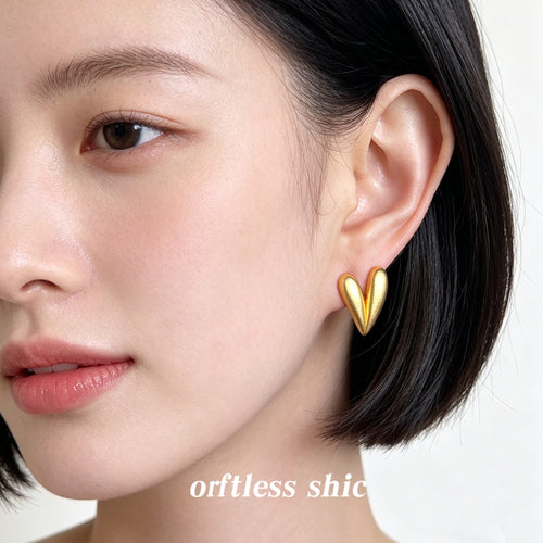 Gold matte heart stud earring worn on ear