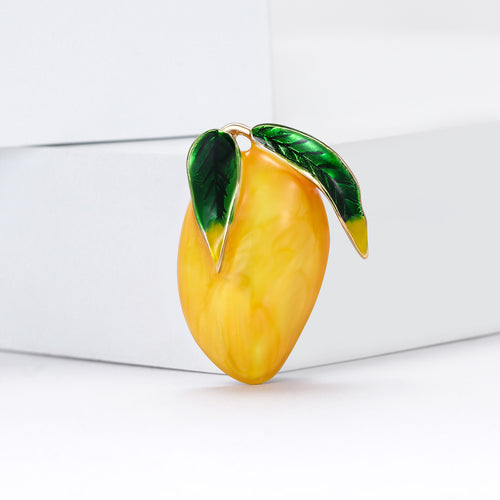 Yellow mango brooch angled on white display block close-up