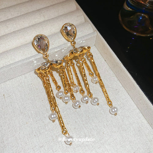 gold tone crystal bar fringe earrings displayed from a second angle