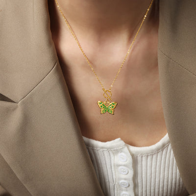 Model wearing gold-tone green enamel butterfly pendant necklace with toggle clasp