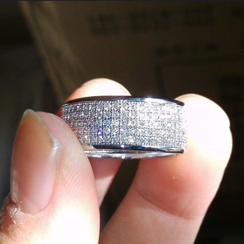 Side view of multi-row pave band ring held in natural light