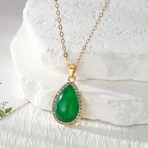 Green teardrop rhinestone pendant necklace on gold cable chain close-up