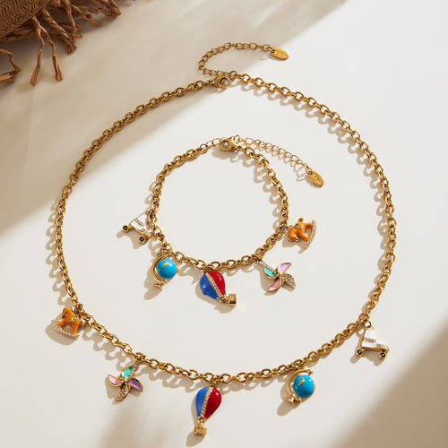 Coordinated set view of travel charm necklace and bracelet in main image 1.