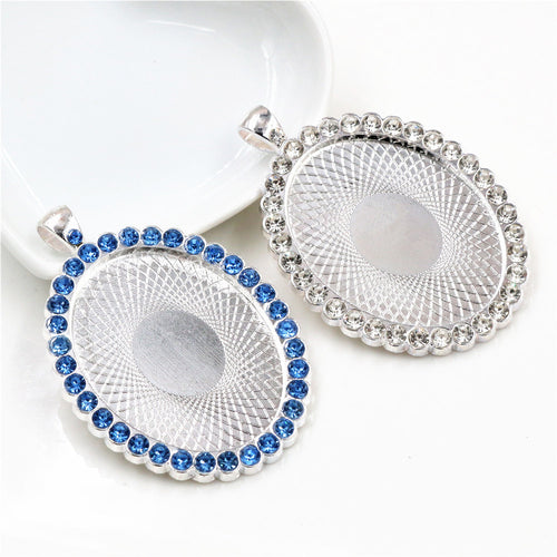 Oval cabochon pendant tray bordered with rhinestones in a group view on a white background