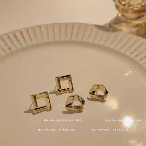 Gold square frame and twisted heart studs on cream plate