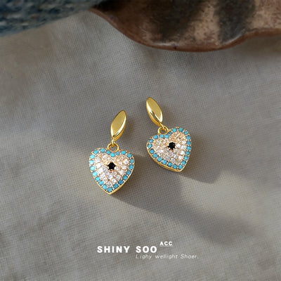 Gold oval stud pave heart drops with turquoise rim on linen