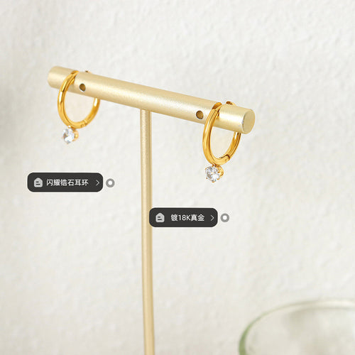 Pair of gold mini hoops with clear drops on T-bar display stand