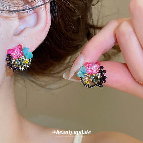 Bright pink and blue crystal-like petals arranged around smoky centers displayed from the front.