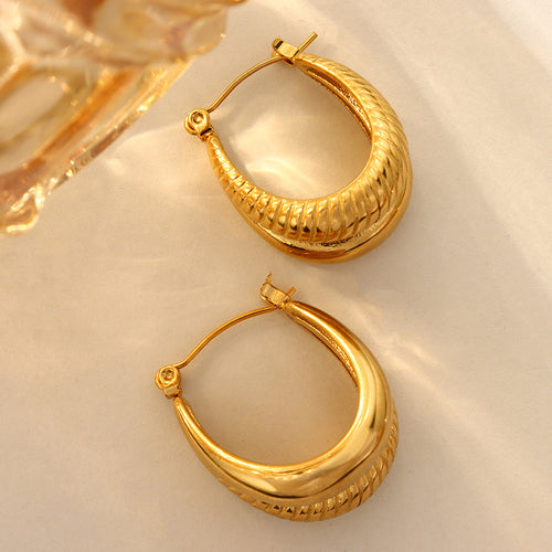 Gold dual layer C hoop earrings on fabric with glass prop