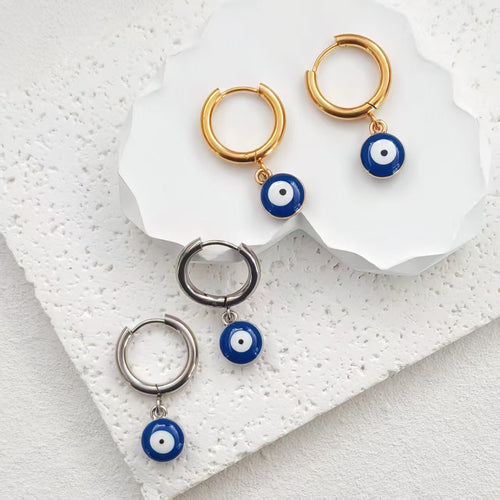 Gold and silver evil eye huggie hoop earrings with blue enamel charms