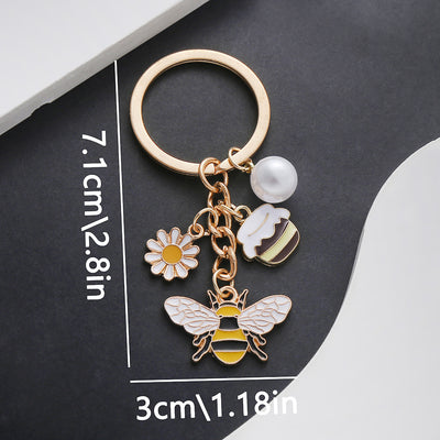 Front product photo of yellow honey jar bee daisy and faux pearl charm keychain showing the pictured design arrangement