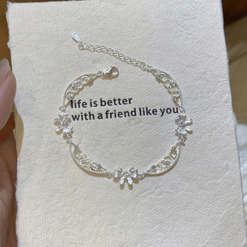 Silver CZ bow openwork lace bracelet coiled on card product shot