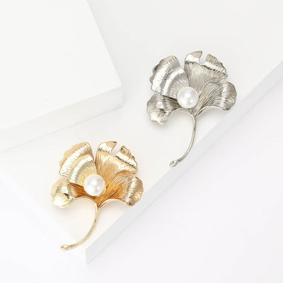Gold and silver matte ginkgo leaf pearl brooches on white