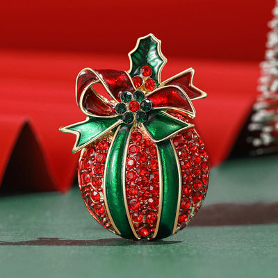 Front view showing the red crystal apple brooch with green enamel bow and leaf