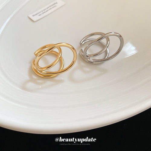 Gold and silver double loop open cuff rings on white plate