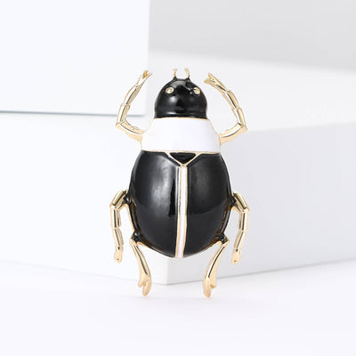 Black Beetle brooch styles arranged on a light display