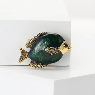 Front view of a rounded dark green fish with textured gold-tone fins