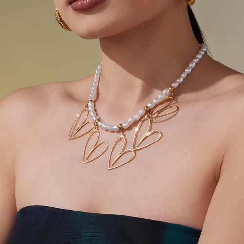 Model wearing gold shell bead open heart multi-pendant necklace