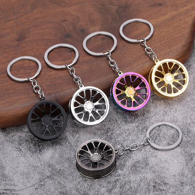 Five wheel rim keychains in black, gunmetal, silver, gold, and rainbow finishes.