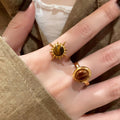 Three Gold Tone Brown Oval Round And Sunburst Stone Ring Designs view 4
