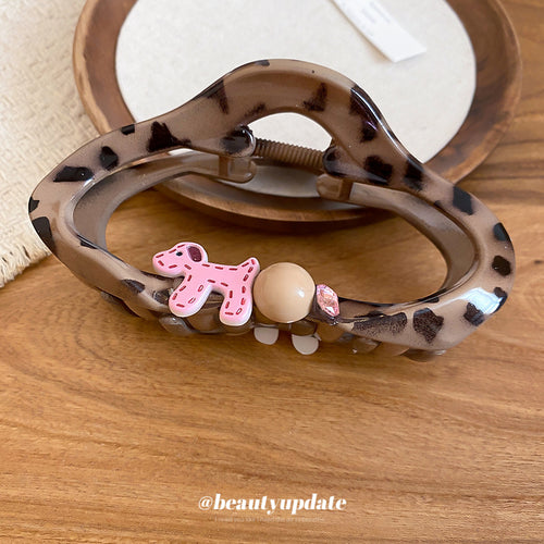 Leopard acrylic claw clip with pink dog bead charm on wooden table