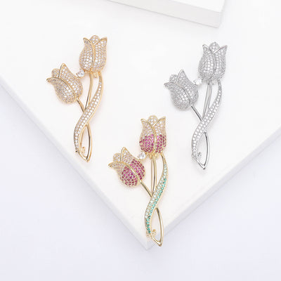 Gold silver and pink double tulip brooches on white