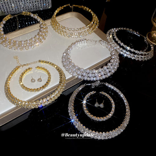 Assorted gold and silver crystal pearl chokers and sets on tray