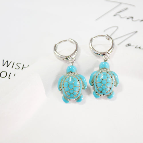Pair of turquoise turtle figure charms on silver huggie hoops