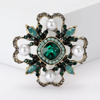 Grouped view of baroque pearl flower brooch with faceted center and marquise leaves arranged together.