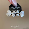 White Bow Stud Earrings With Gold Tone Speckled Detail view 2