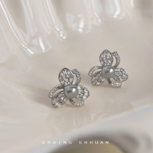 Silver gray pearl flower studs on creamy ceramic dish