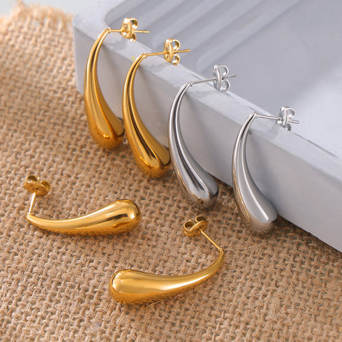 Gold and silver smooth teardrop studs on burlap and tray