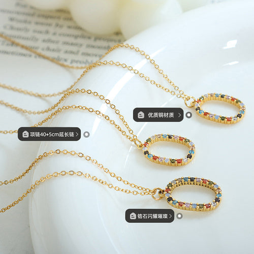 Three gold oval multicolor zircon pendants on white dish with material labels