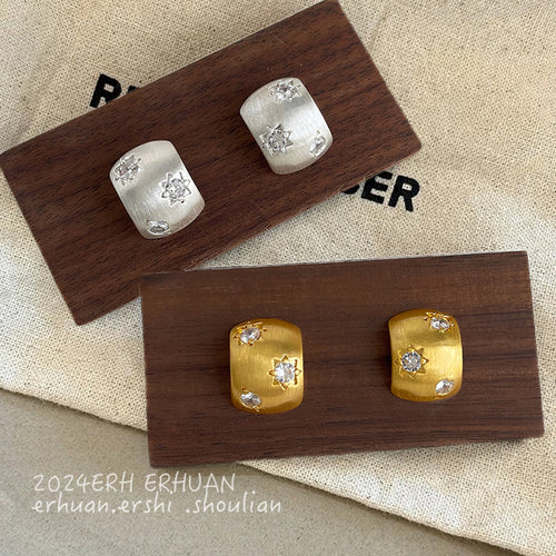 Brushed curved clear-stone studs showing both finishes.