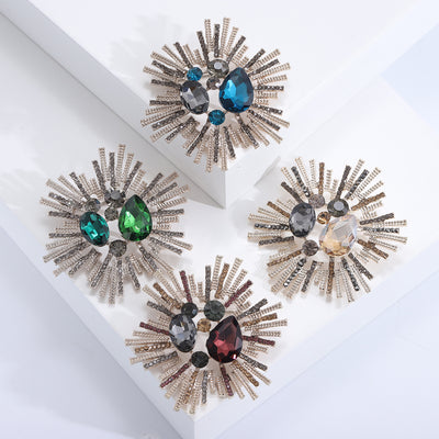Front view of statement radiating crystal burst brooch in four colorways