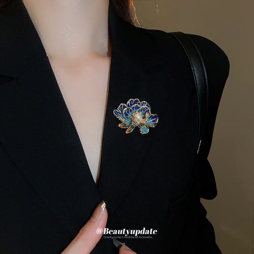 gold-tone pink enamel flower brooch with a pearl-like center shown in the first close product view