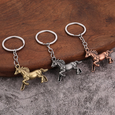Three galloping horse keychains in antique bronze, antique silver, and antique copper finishes.