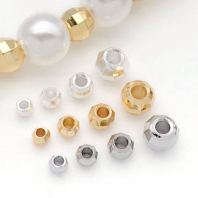 Front overview of diamond facet pattern metal spacer beads arranged by finish and size