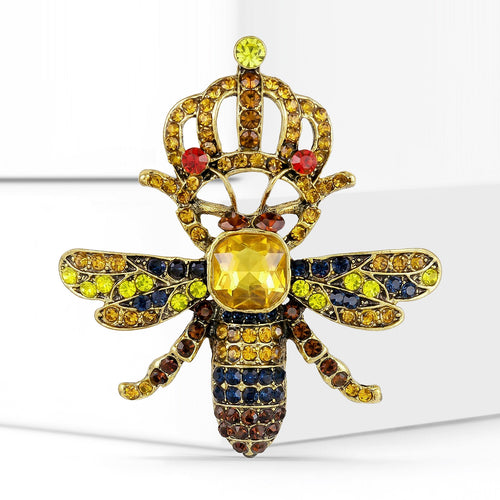 Crowned bee brooch front close-up on white geometric blocks